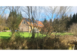 Das Forsthaus von außen, umgeben vom Wald