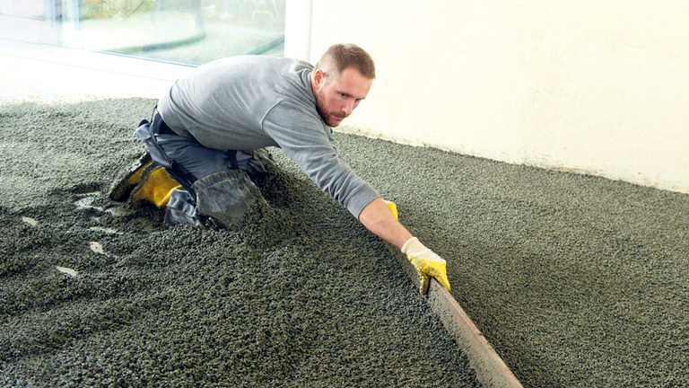 Handwerker arbeitet mit der Ausgleichsschüttung FISCHER cyclepor®